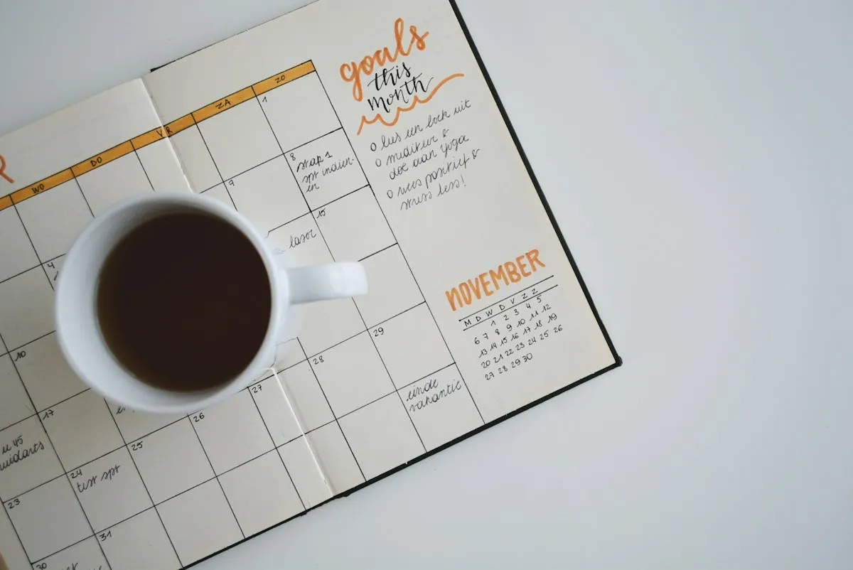 Desk calendar and coffee beside handwritten planning notes