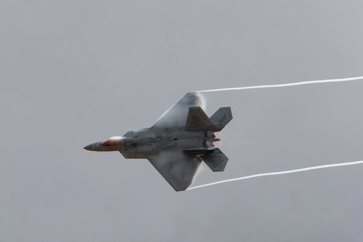 United States Air Force F-22 Raptor fighter jet in flight with visible vapor trails