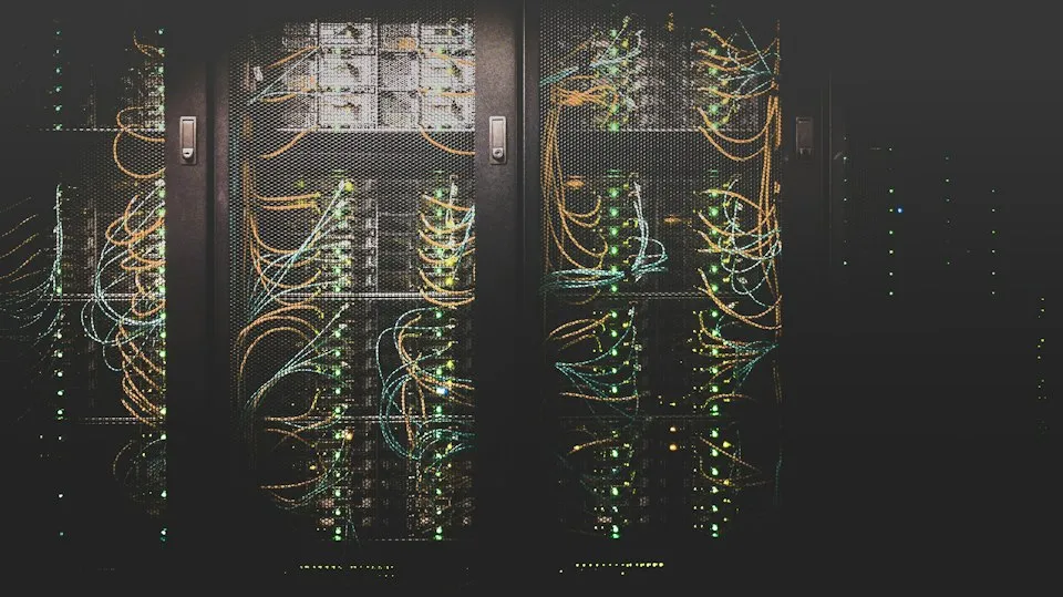 Server racks with illuminated network cables in a dark data center