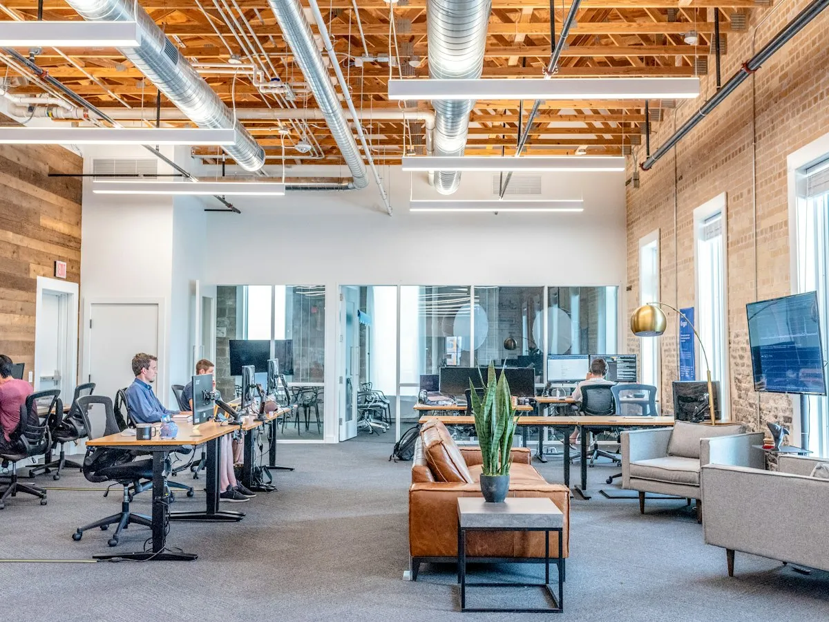 Colleagues reviewing code and laptop workstations in an office