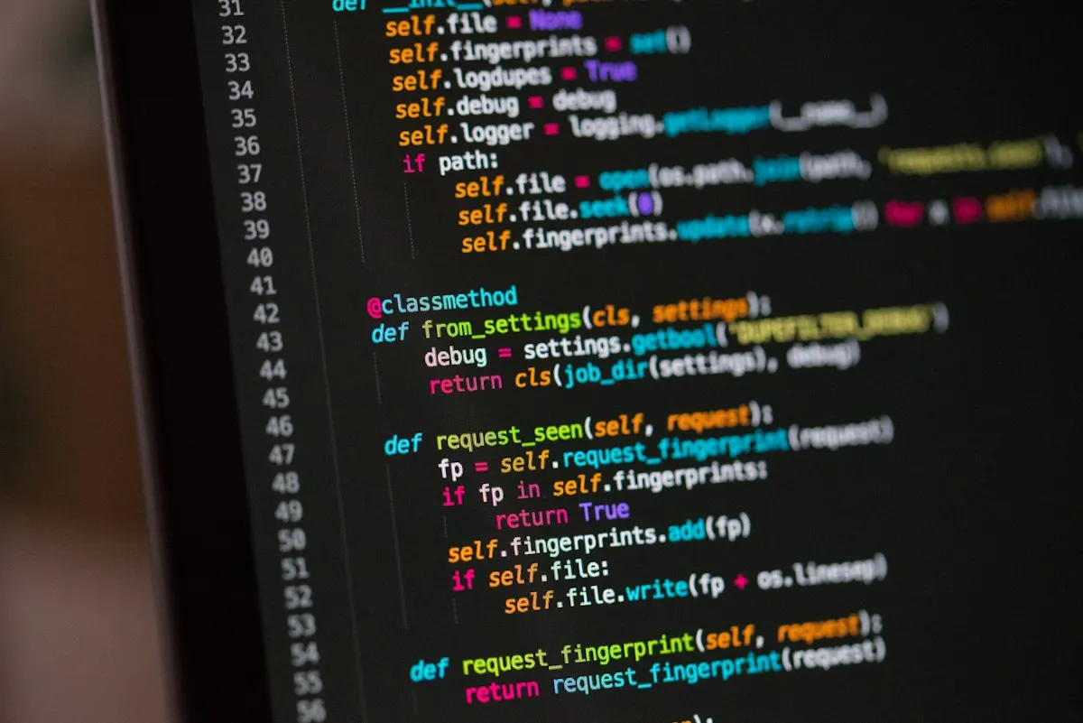 Two people working at computers with code visible